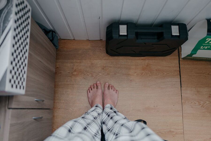 Looking down at bare feet on a wooden floor