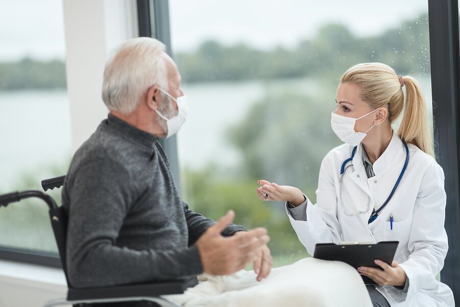 A doctor talking with an older patient in a clinic